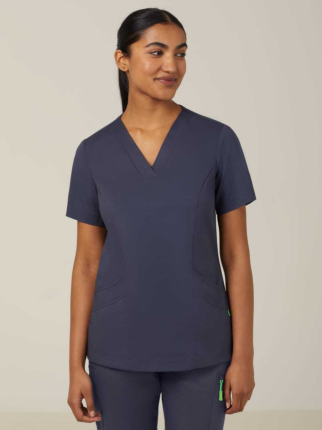 A woman wearing a navy blue scrub top and pants.