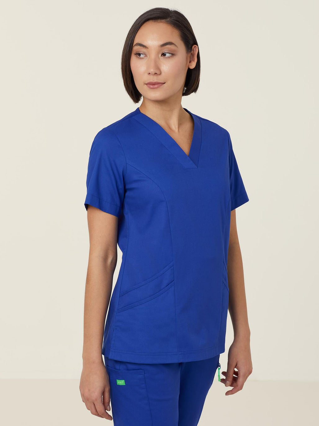 A woman wearing blue scrubs.
