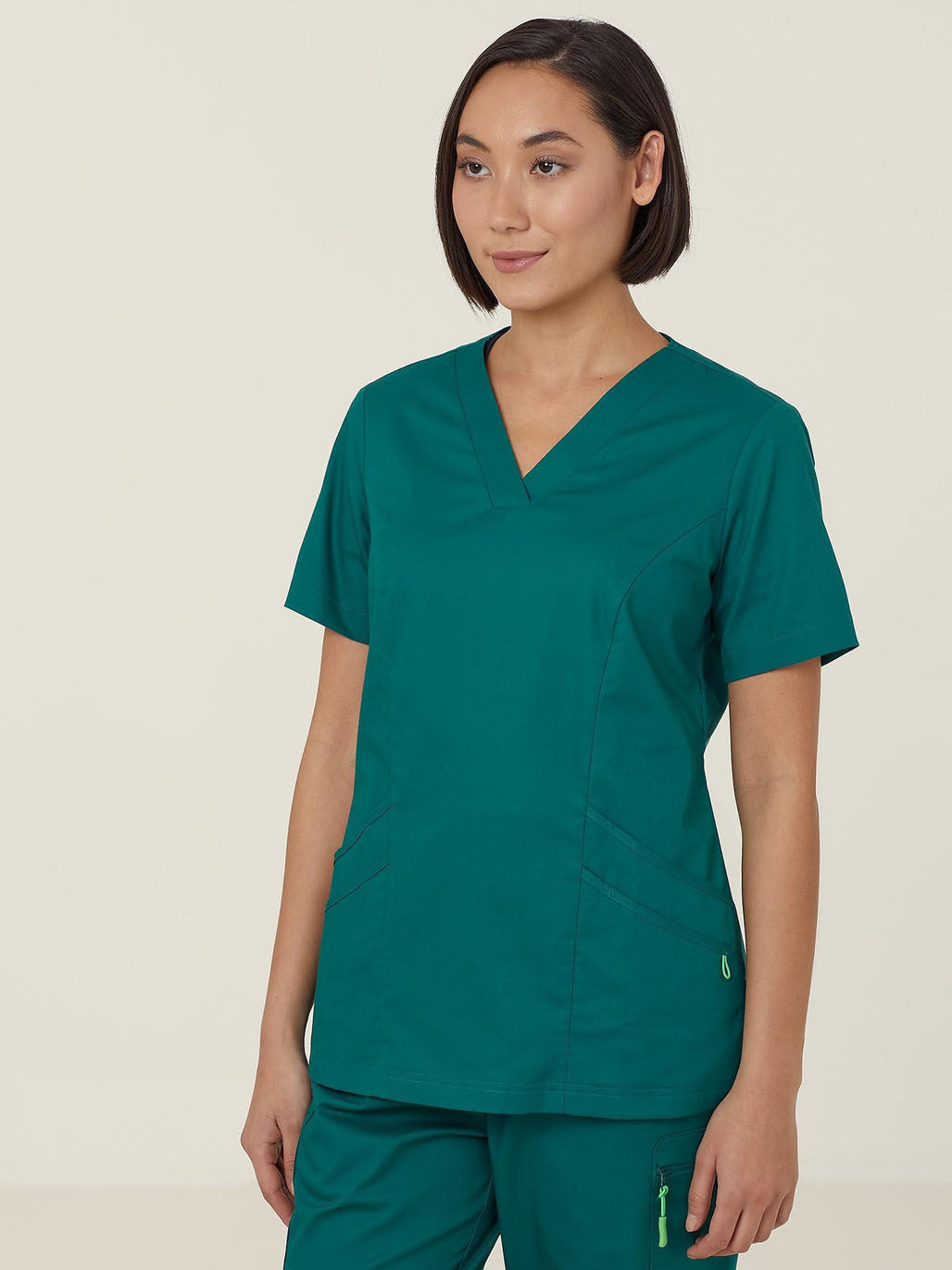 A woman wearing green scrubs.