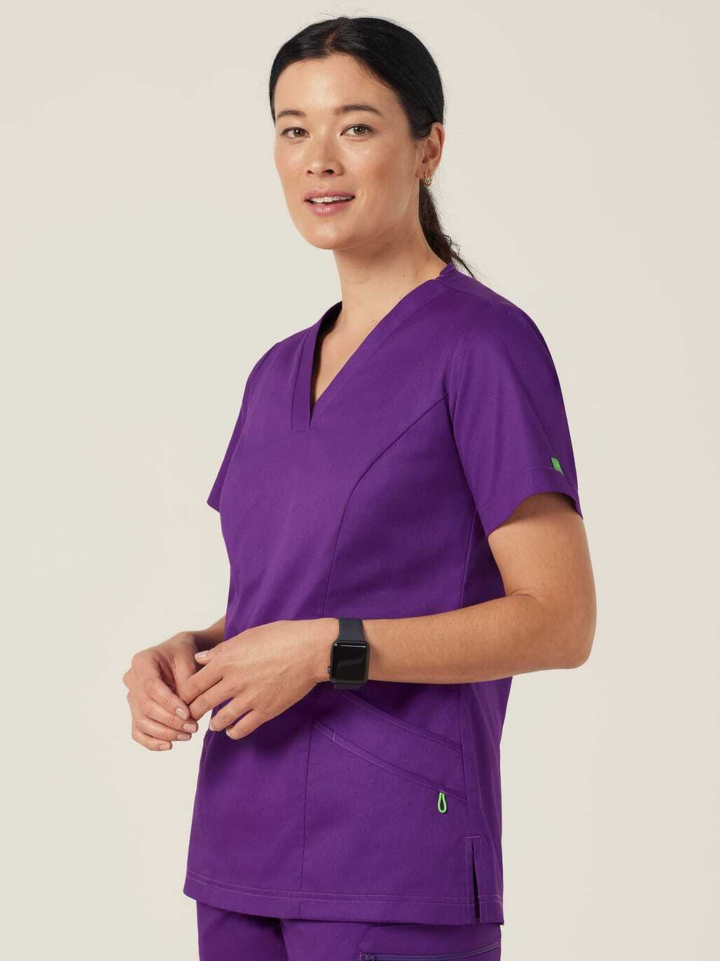 A woman in purple scrubs with a black watch on her wrist.